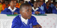 Dreng i skole i Uganda